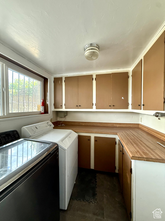 Laundry area featuring separate washer and dryer and cabinet space