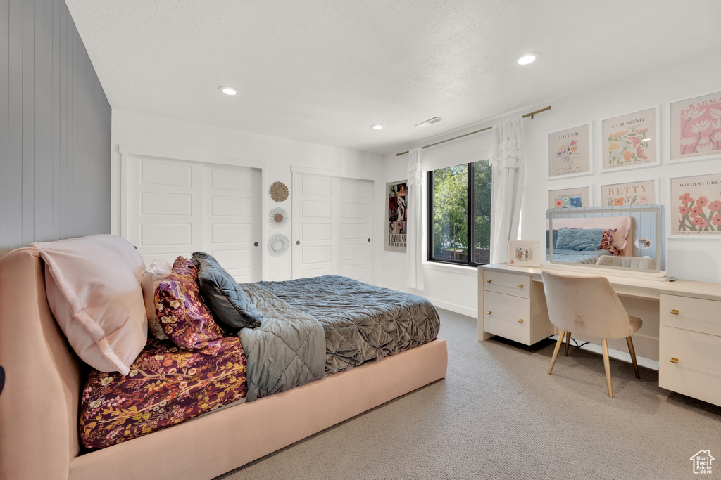 Carpeted bedroom featuring multiple closets, an office area, and recessed lighting