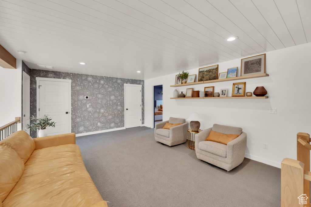 Carpeted living area featuring wallpapered walls, baseboards, and recessed lighting