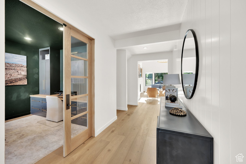 Hall with light wood-style floors, baseboards, french doors, and recessed lighting