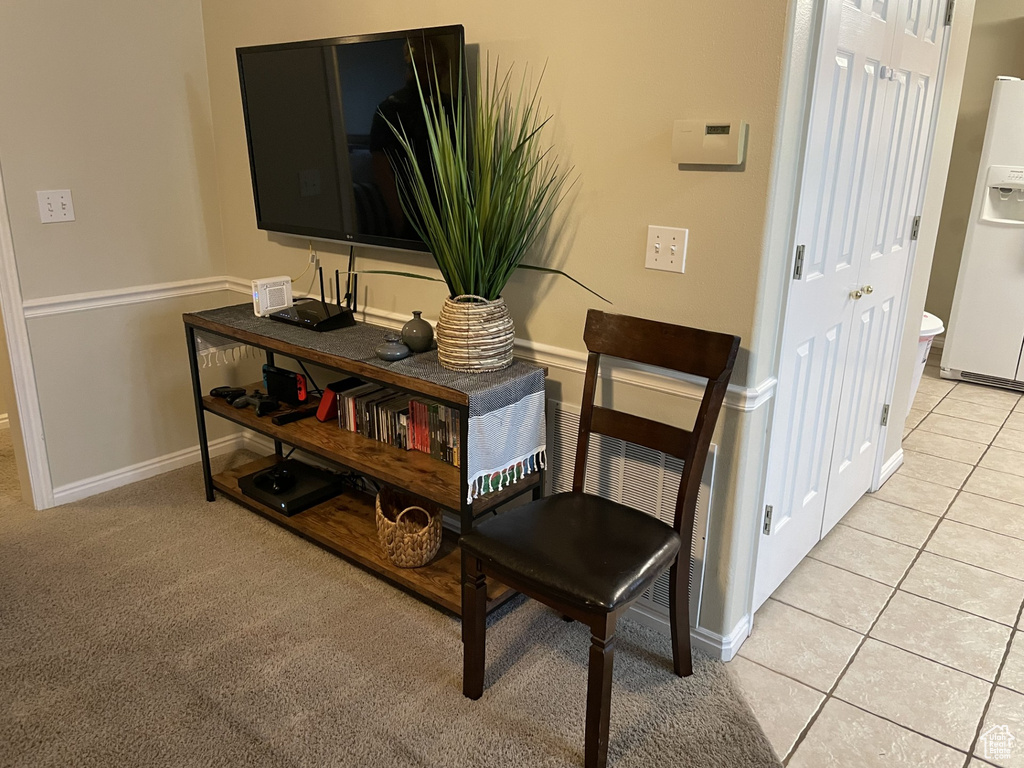 Detailed view of white fridge with ice dispenser and baseboards