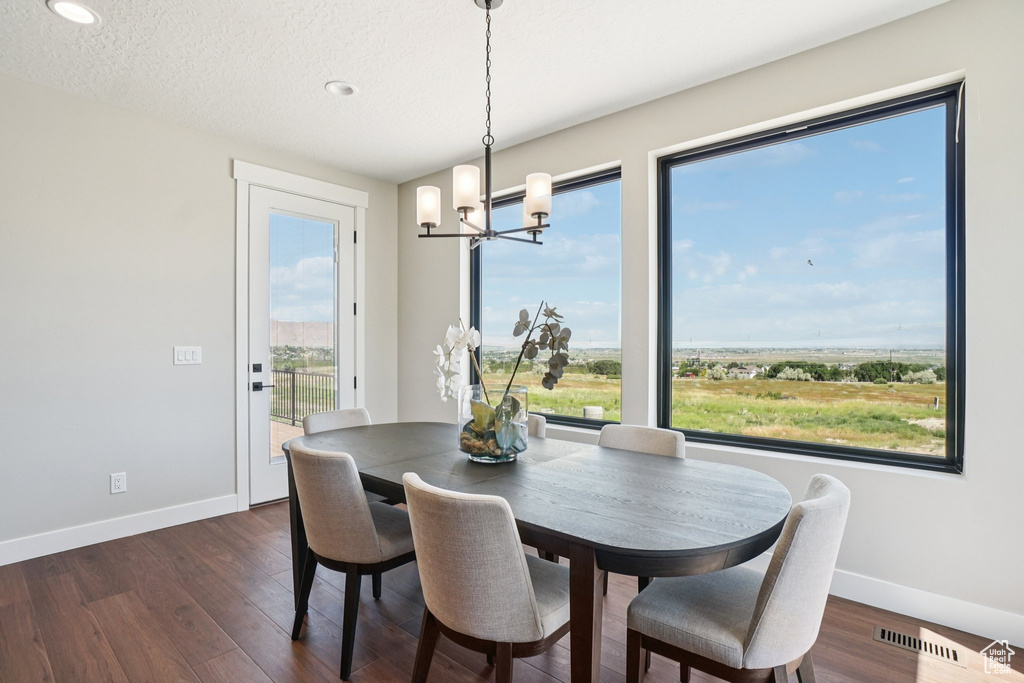 Dining area featuring a chandelier, baseboards, dark wood-style floors, and recessed lighting