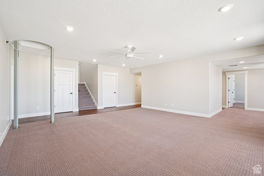 Unfurnished room featuring a ceiling fan, stairway, recessed lighting, carpet floors, and a textured ceiling