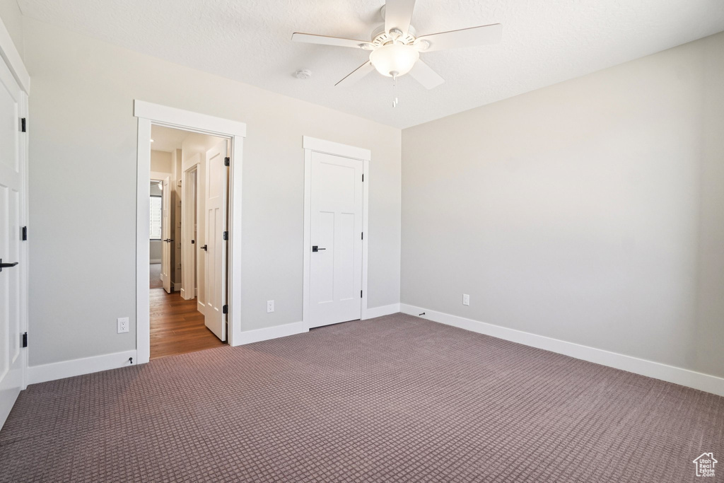 Unfurnished bedroom featuring carpet flooring, baseboards, and ceiling fan