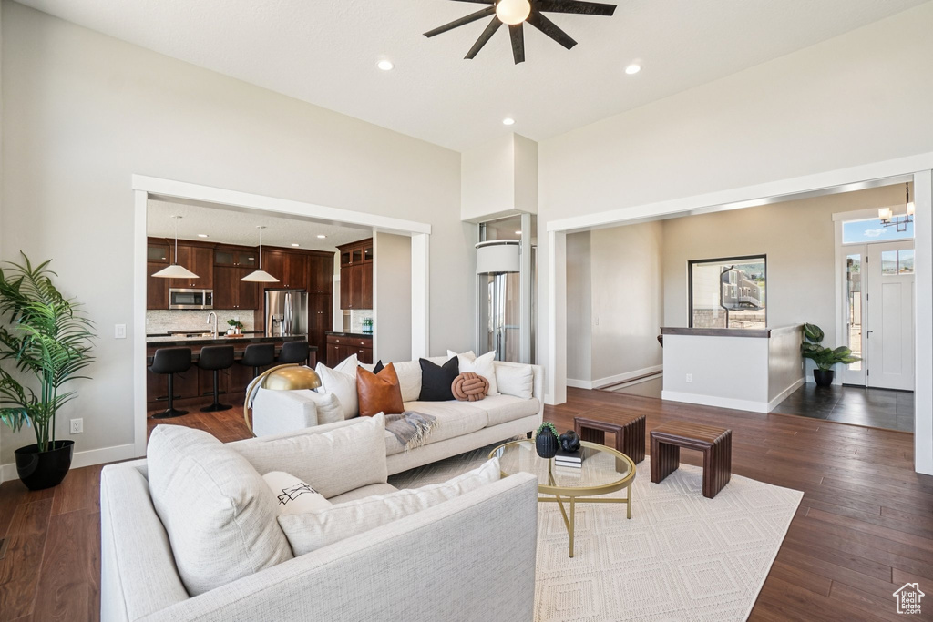 Living room with ceiling fan, recessed lighting, dark wood-style floors, and baseboards