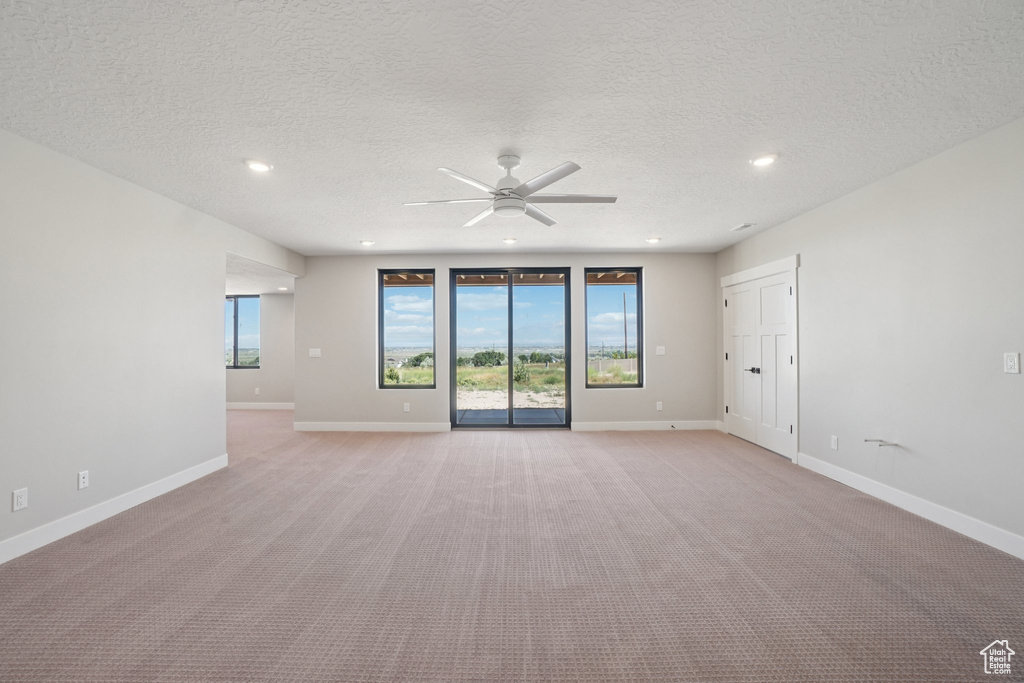 Unfurnished room featuring ceiling fan, light carpet, recessed lighting, baseboards, and a textured ceiling
