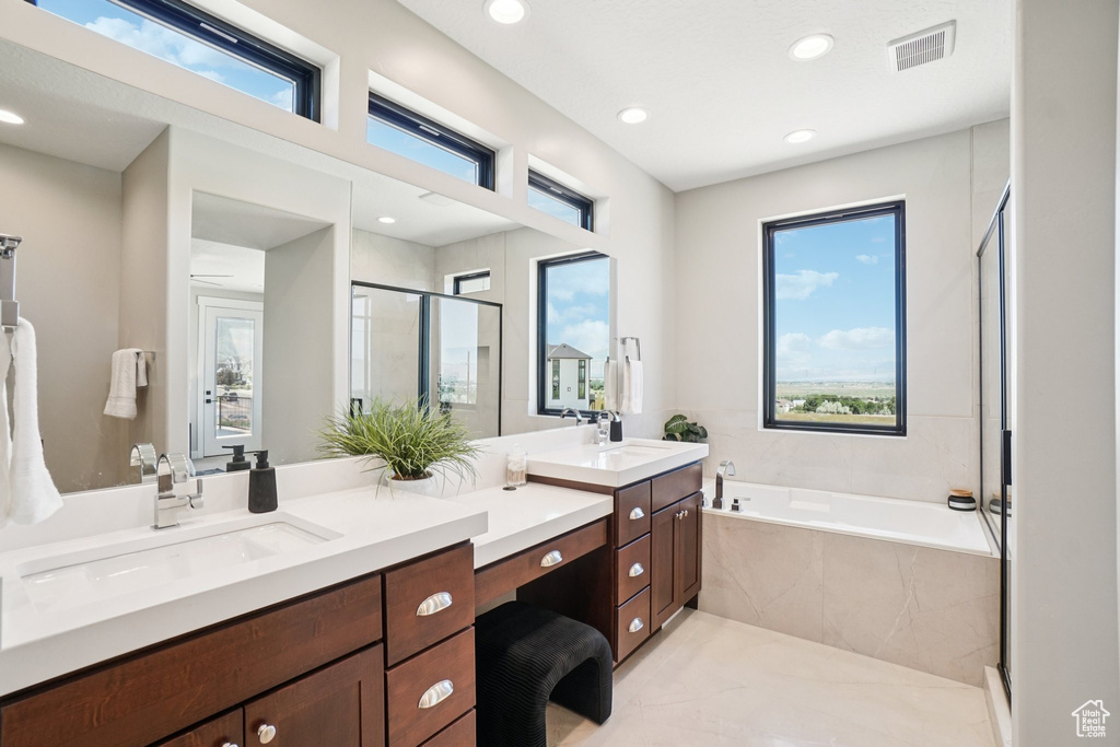 Full bath with double vanity, a bath, a shower stall, and recessed lighting