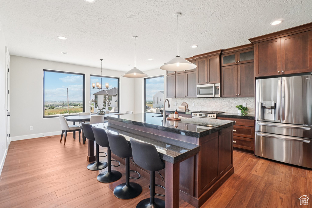 Kitchen featuring stainless steel appliances, baseboards, plenty of natural light, glass insert cabinets, and recessed lighting