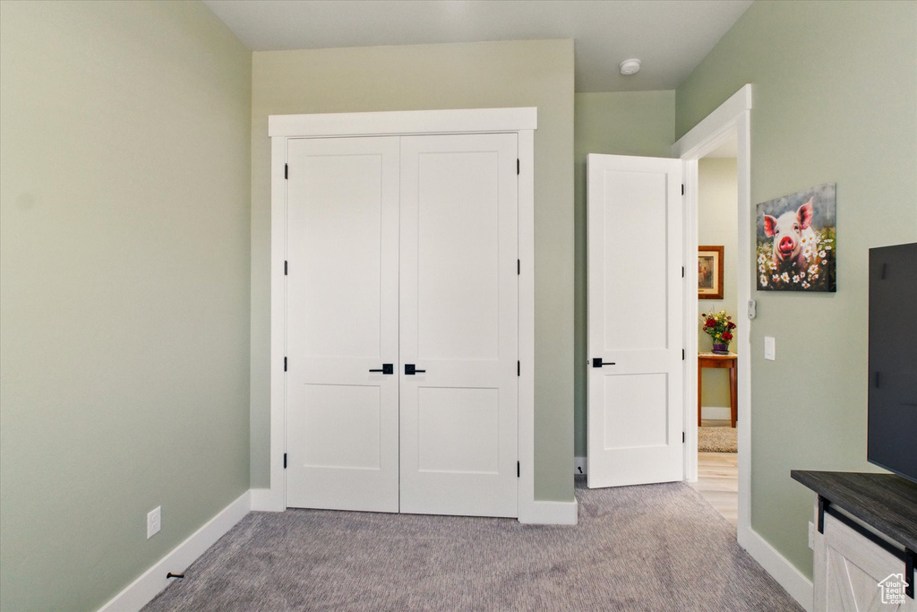 Unfurnished bedroom featuring baseboards, carpet floors, and a closet