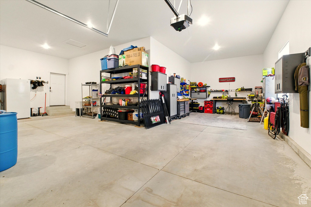 Garage featuring a garage door opener and a workshop area