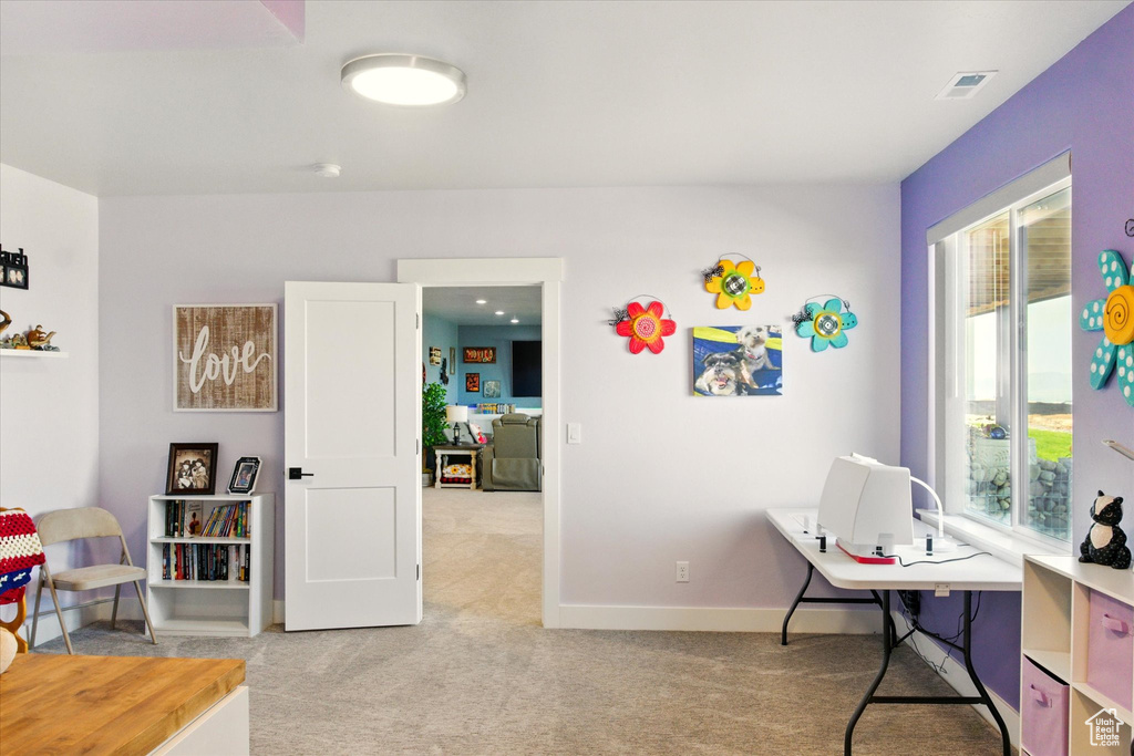 Office space featuring light carpet, plenty of natural light, and baseboards