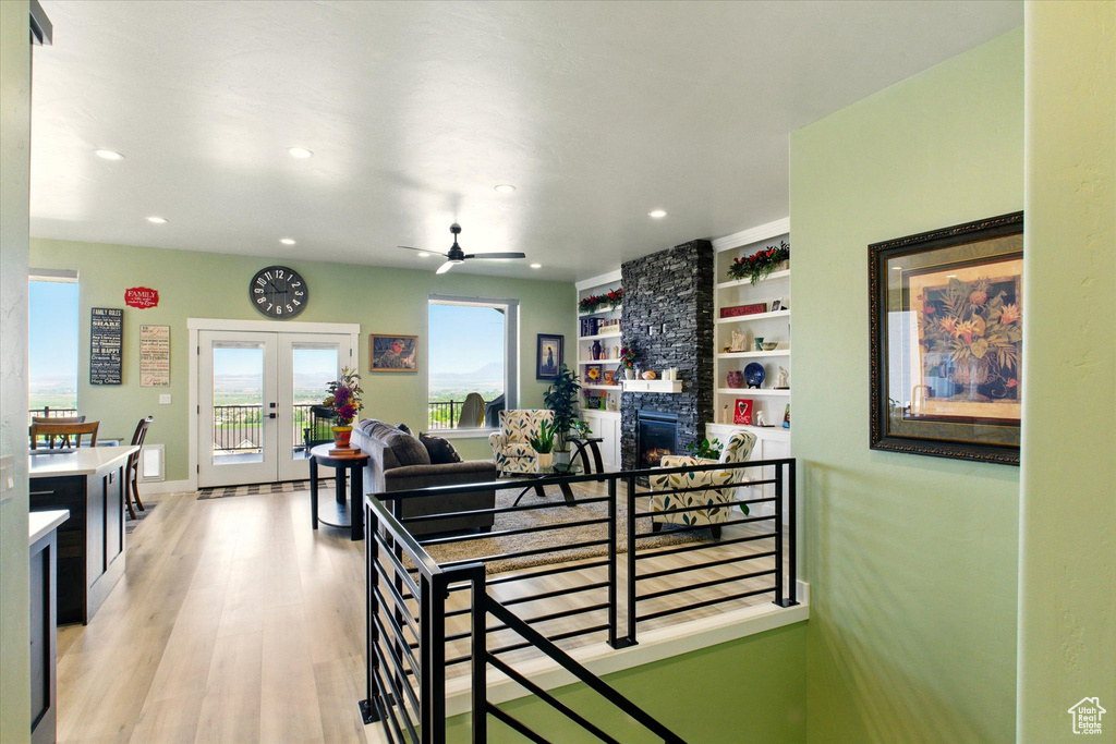 Corridor featuring french doors, light wood-style flooring, recessed lighting, baseboards, and built in shelves