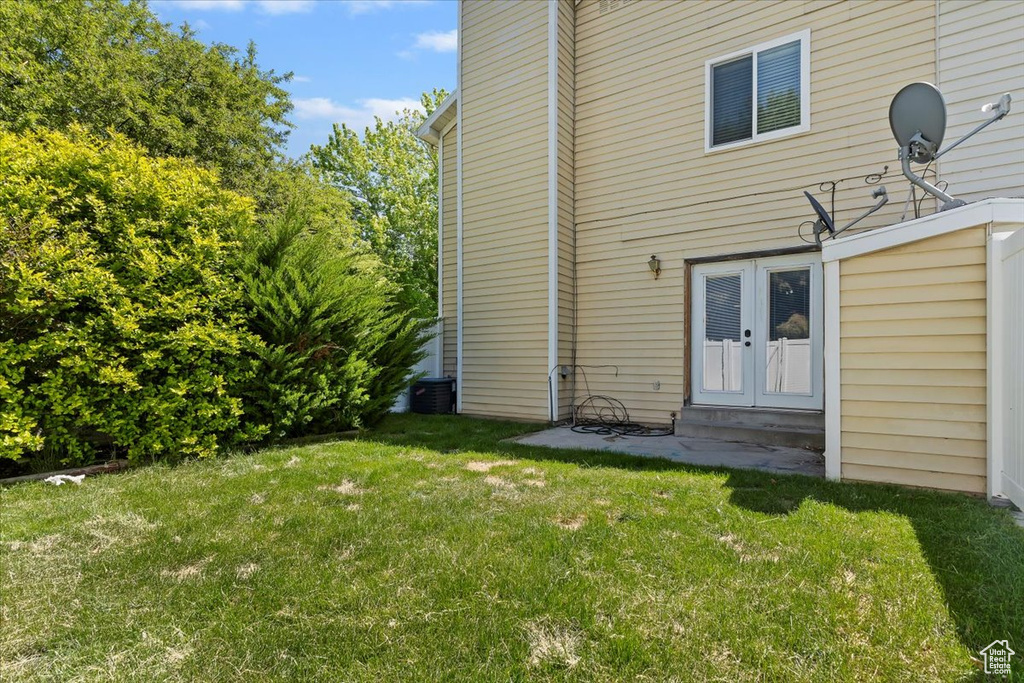 Back of property with a yard and french doors
