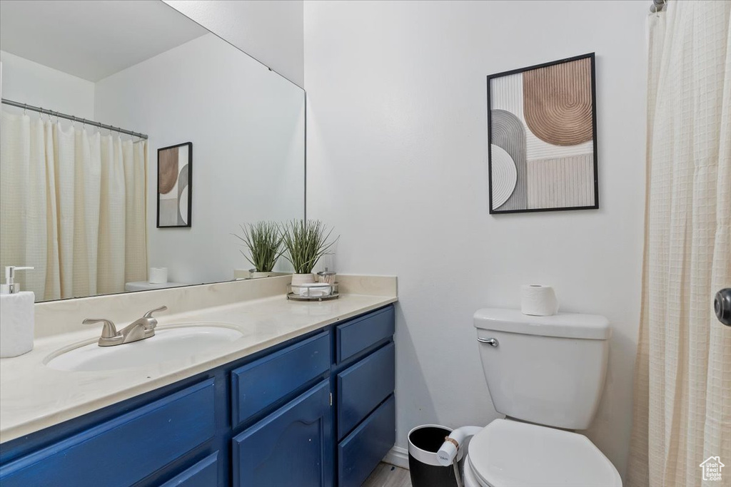 Full bath featuring vanity, toilet, and a shower with shower curtain