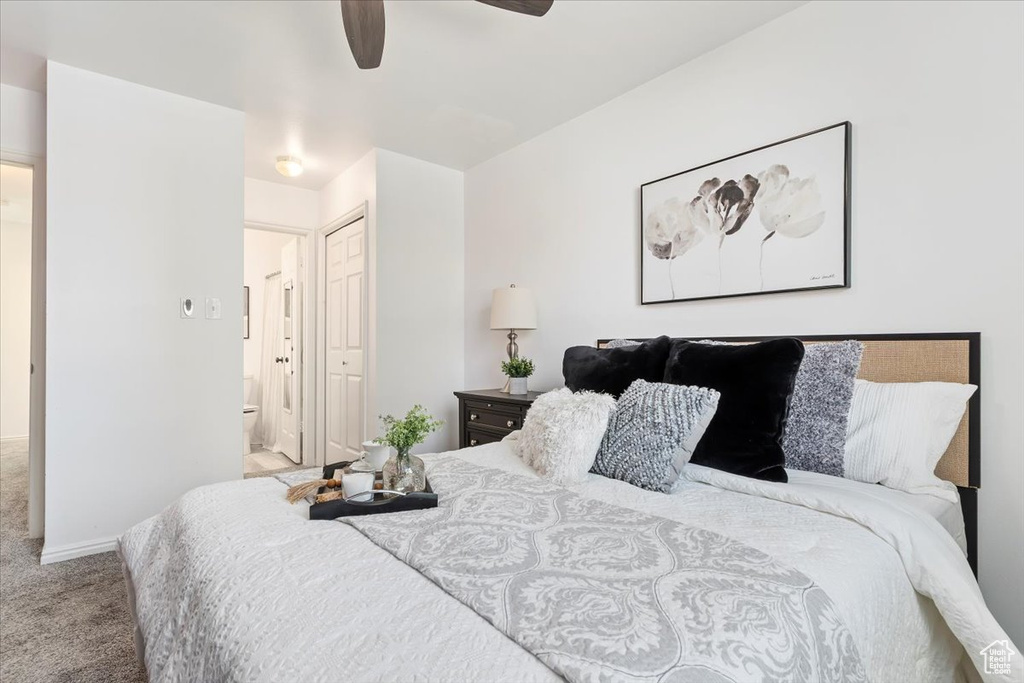 Bedroom with carpet floors, a closet, ensuite bathroom, and a ceiling fan