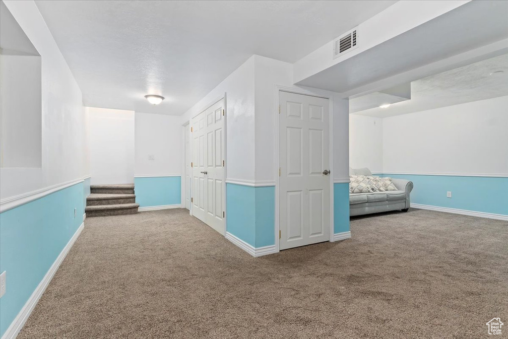 Hall featuring carpet, baseboards, and stairs