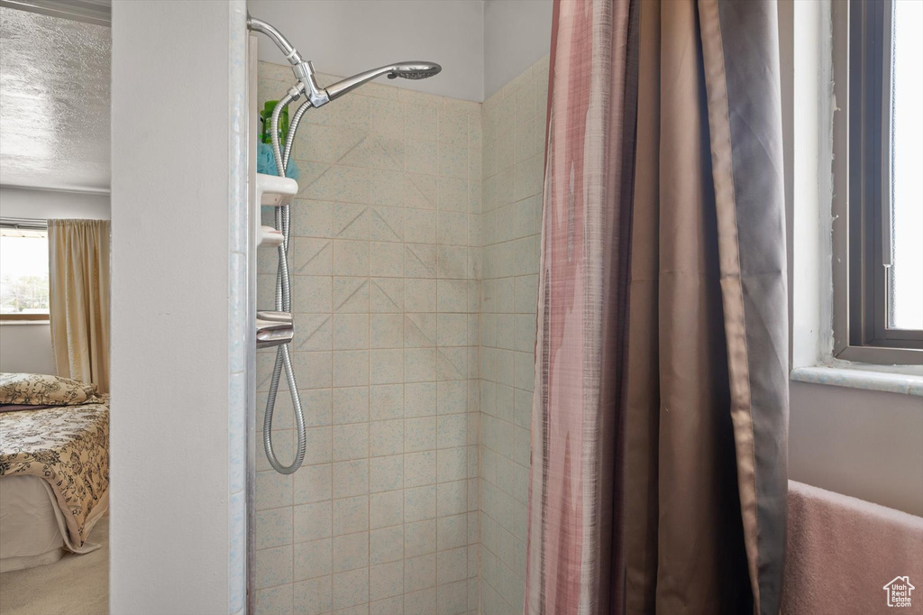Full bathroom featuring a tile shower and a textured ceiling