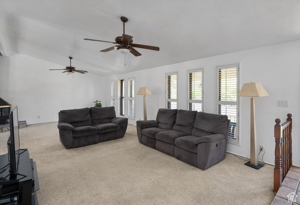 Living room featuring carpet, lofted ceiling, and a ceiling fan