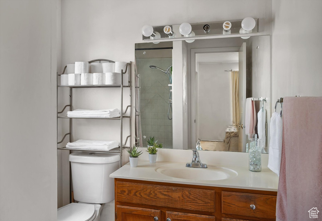 Bathroom with vanity, toilet, and a tile shower