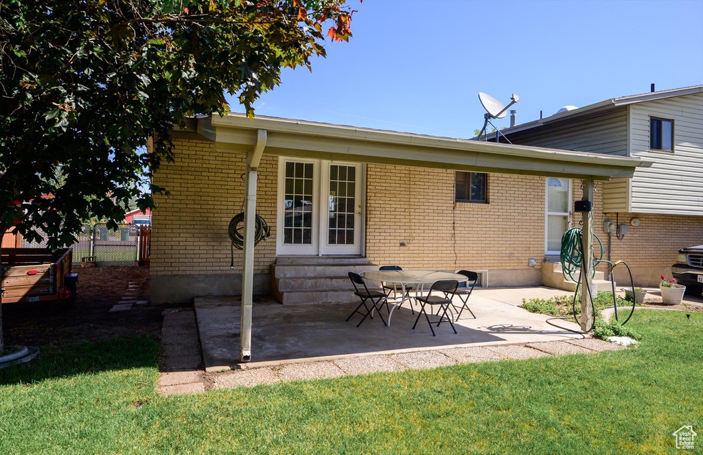 Back of house with entry steps, brick siding, and a patio area