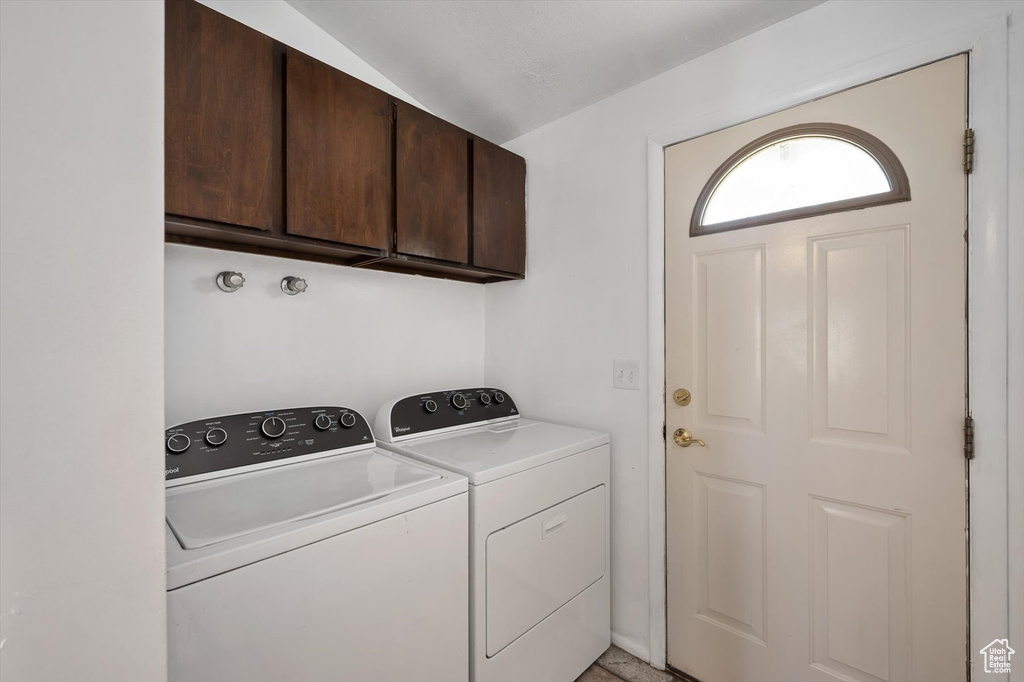 Washroom with cabinet space and washing machine and clothes dryer