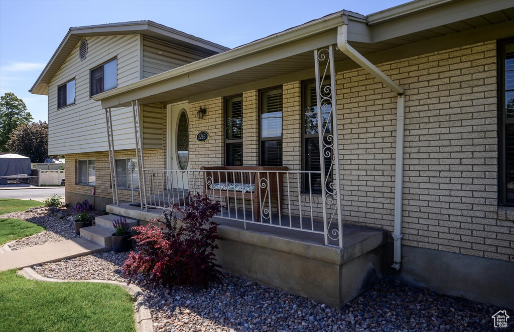 View of front facade featuring covered porch and brick siding