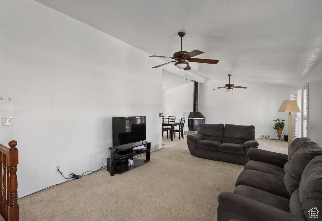 Living area with carpet floors, vaulted ceiling, and ceiling fan