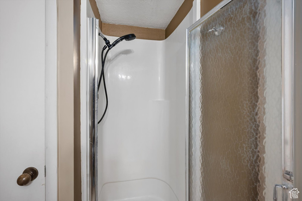 Bathroom view of a stall shower and a textured ceiling