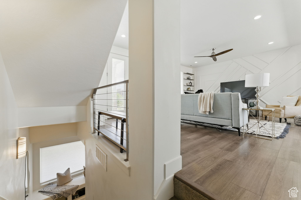 Stairs with a ceiling fan, recessed lighting, and wood finished floors