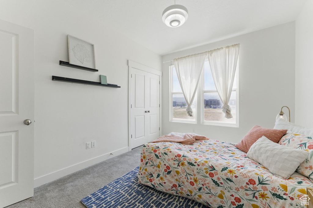 Bedroom with carpet floors, baseboards, and a closet