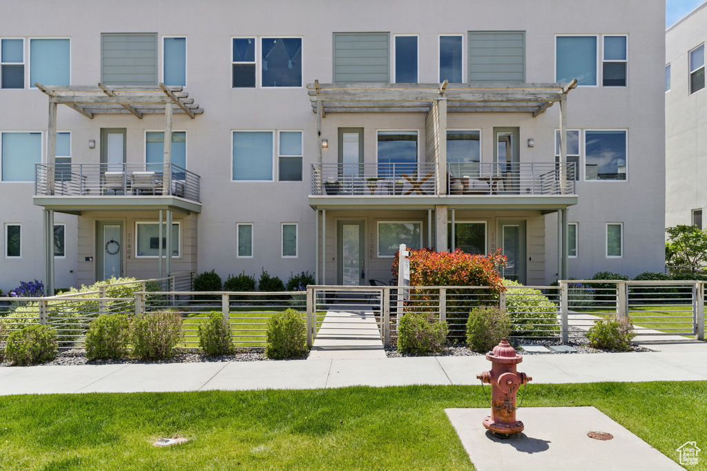 Multi unit property with a pergola and stucco siding
