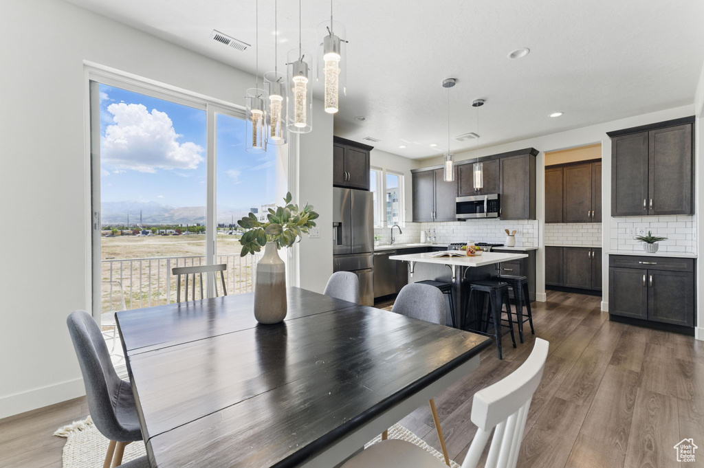 Dining area featuring wood finished floors, recessed lighting, a chandelier, and baseboards