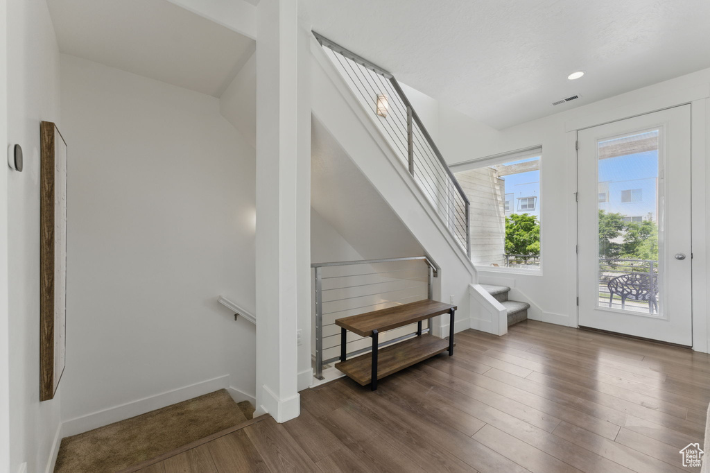 Foyer with wood finished floors, baseboards, stairs, and recessed lighting