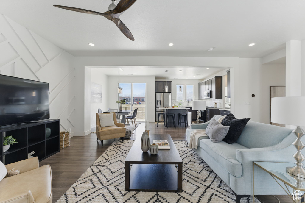 Living area with a ceiling fan, dark wood-type flooring, and recessed lighting