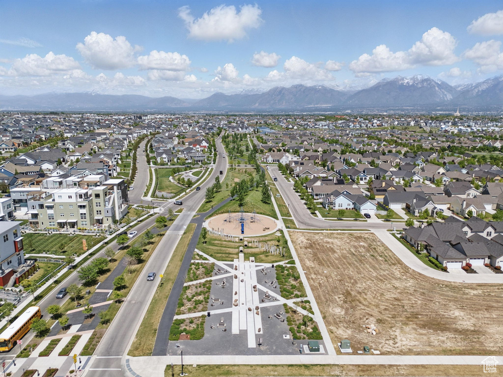 Aerial view of property and surrounding area featuring mountains and nearby suburban area