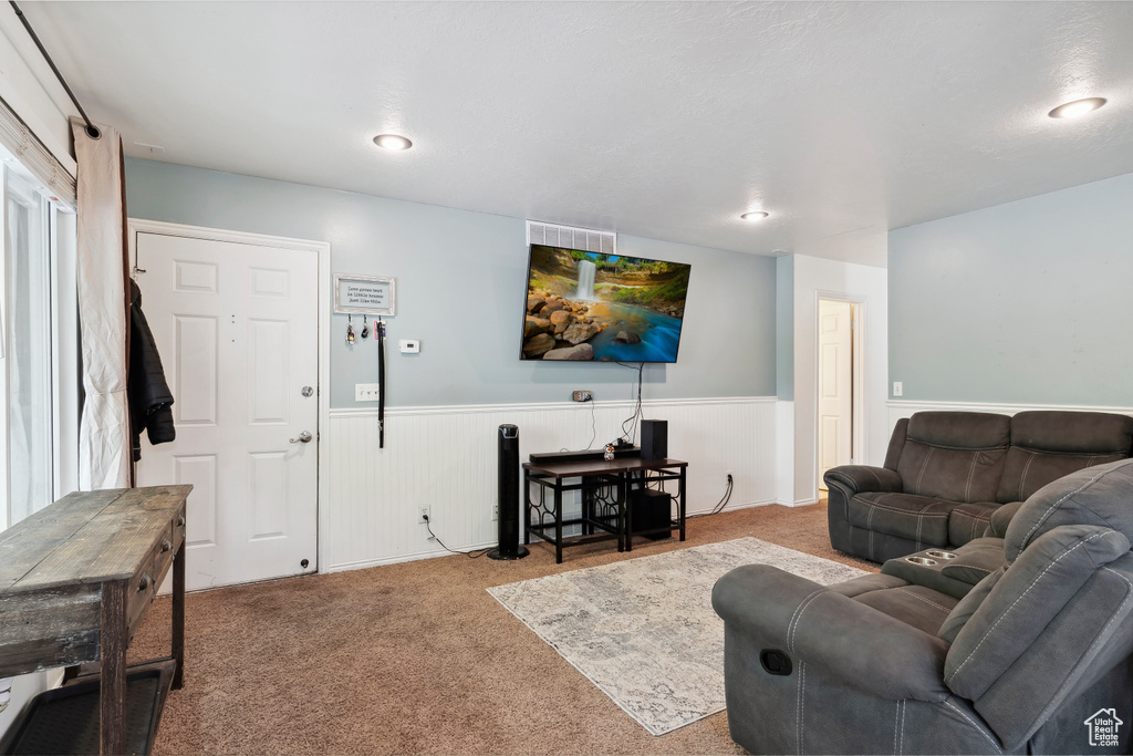 Carpeted living area featuring wainscoting and recessed lighting