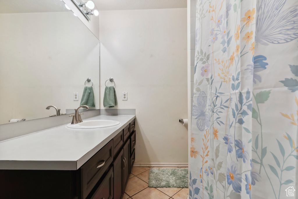 Full bath featuring vanity, tile patterned flooring, baseboards, and a shower with shower curtain