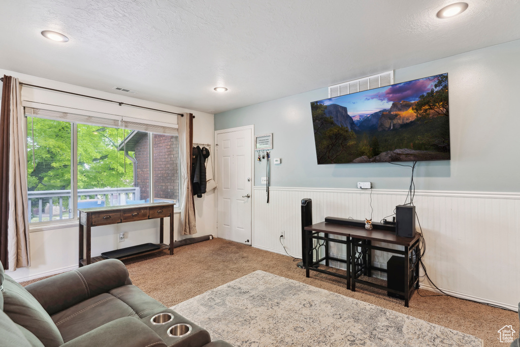 Living area with wainscoting, carpet flooring, a textured ceiling, and recessed lighting