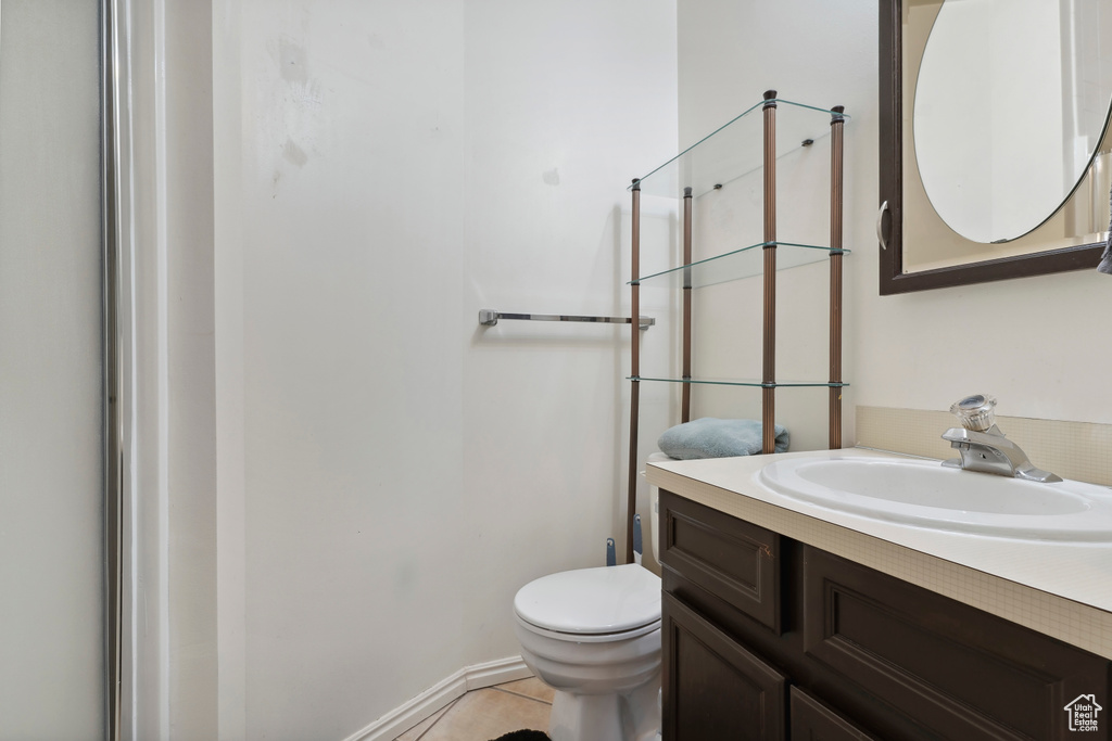 Bathroom with vanity, toilet, a shower, and tile patterned flooring
