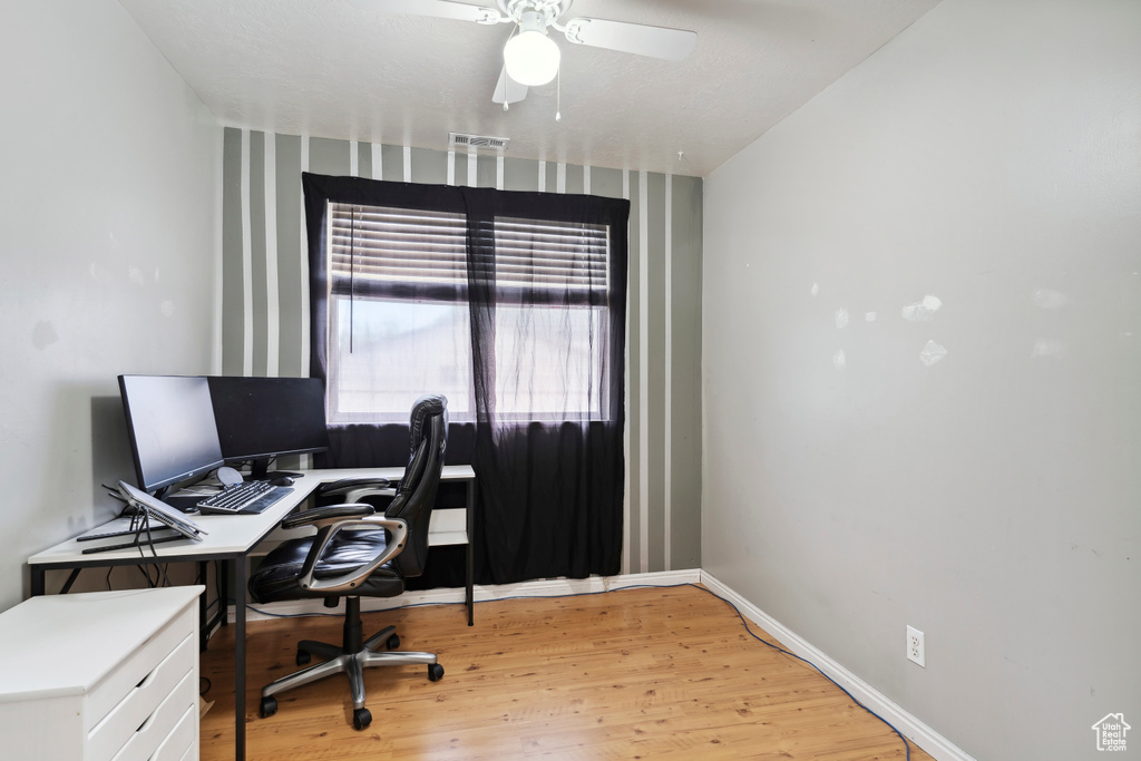 Office with light wood-type flooring, ceiling fan, and baseboards