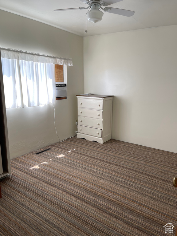 Carpeted spare room featuring a ceiling fan
