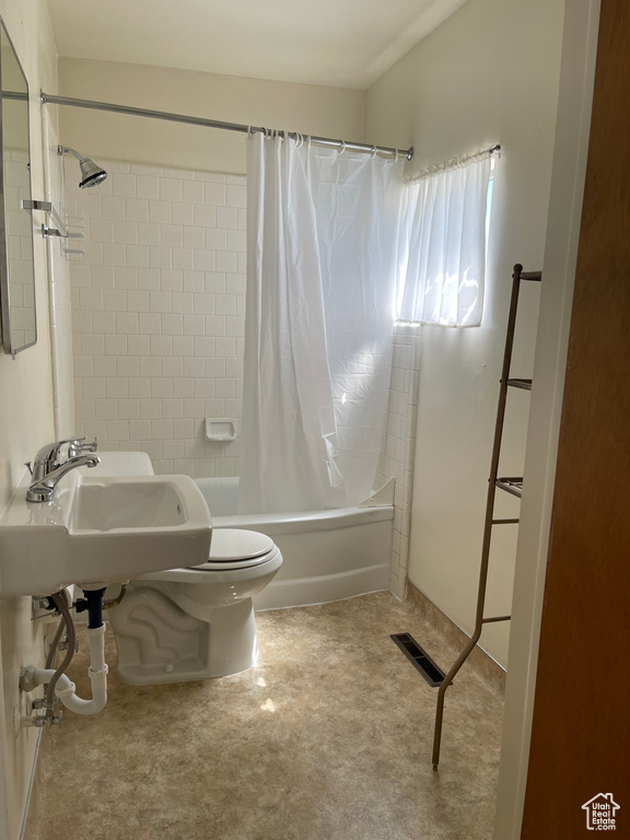 Full bathroom with shower / bath combination with curtain, toilet, and a sink