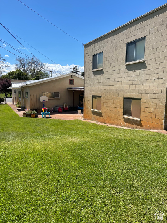 Rear view of house featuring a lawn and a patio