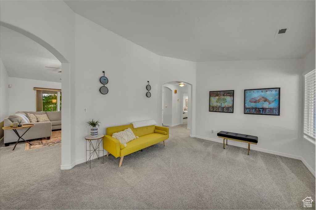 Sitting room with arched walkways, carpet flooring, and baseboards