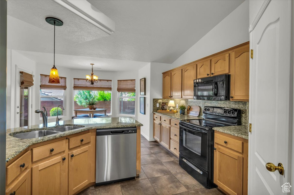 Kitchen with black appliances, a sink, backsplash, light stone countertops, and vaulted ceiling