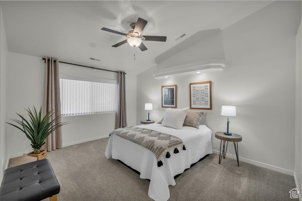 Carpeted bedroom featuring lofted ceiling, baseboards, and ceiling fan
