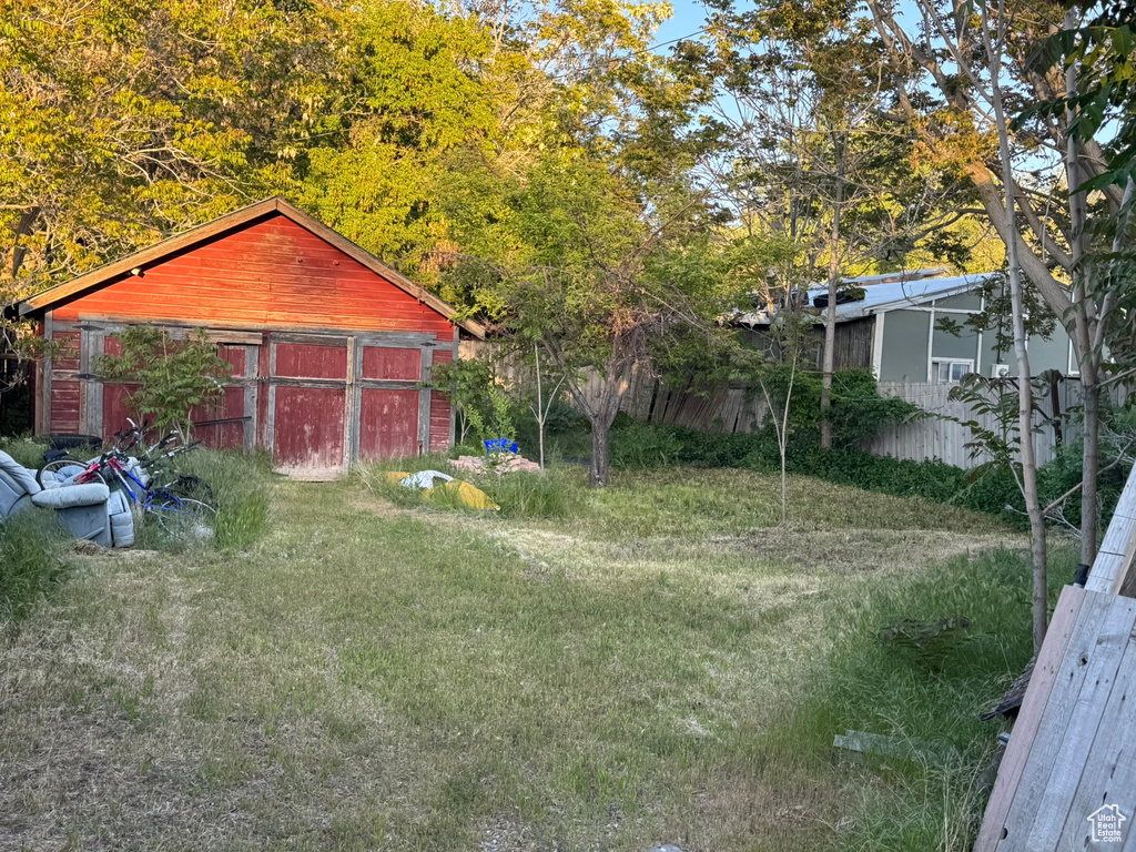 View of yard featuring a garage and an outbuilding