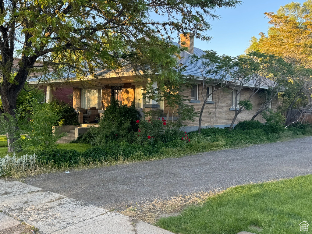 View of front of property featuring brick siding and a chimney