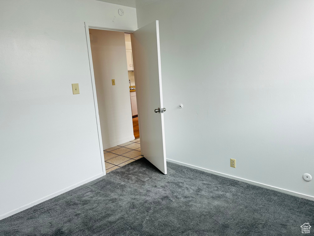 Tiled spare room with carpet flooring and baseboards