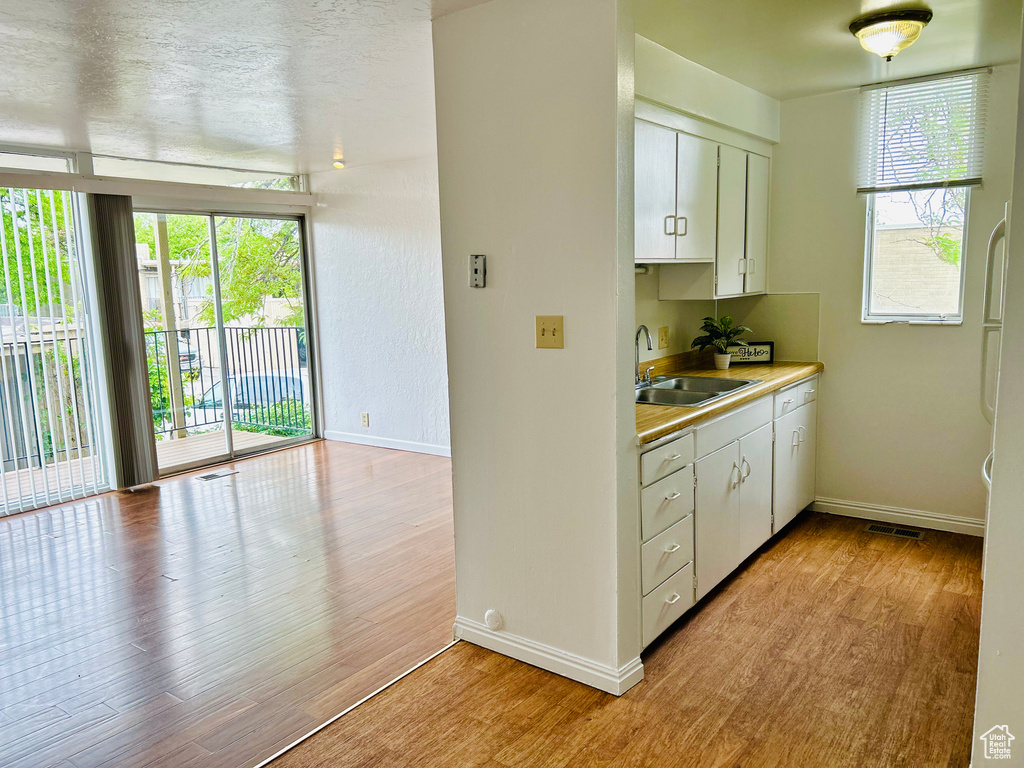 Kitchen featuring a sink, light wood-type flooring, and baseboards